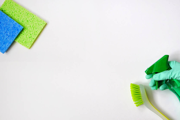 Set de artículos de limpieza en blanco y verde sobre fondo blanco. Detergentes en spray. Vista superior. De cerca.
. - Foto, imagen