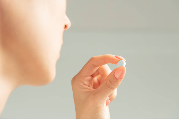 Femme tenant une pilule médicale ou une vitamine
. - Photo, image