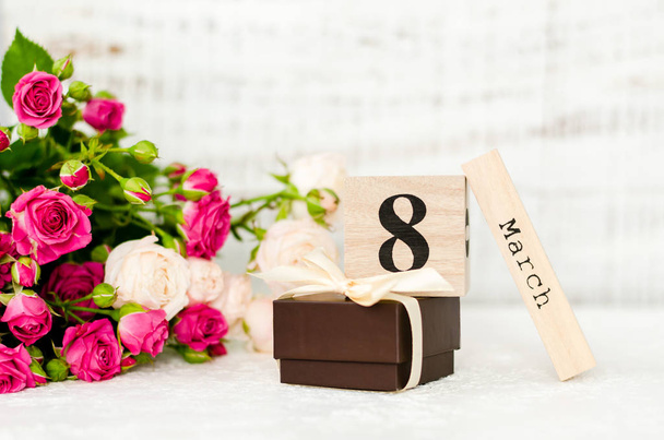 March 8 date on a wooden calendar and rose on a white background. Greeting card for 8 March Woman's Day.  - Photo, Image