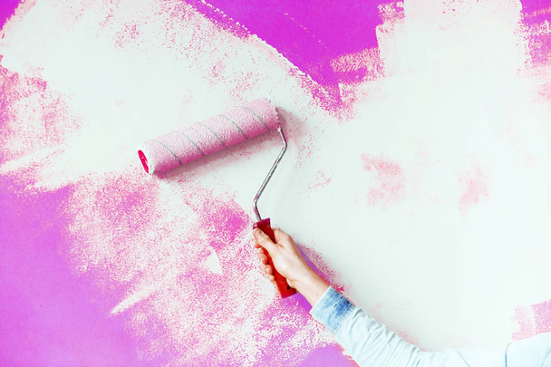 Γυναικείο χέρι ζωγραφική τοίχο με ρολό χρώμα. Κλείσιμο του Decorat - Φωτογραφία, εικόνα
