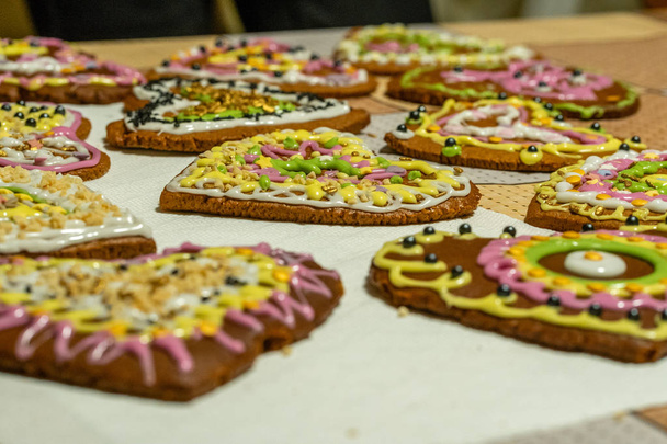 Biscoitos de gengibre decorados em forma de coração alinhados na mesa vista close-up com foco seletivo
 - Foto, Imagem