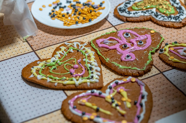 Biscoitos de gengibre decorados em forma de coração alinhados na mesa
 - Foto, Imagem