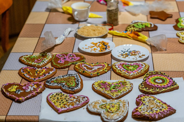 Διακοσμημένα μπισκότα μελόψωμο σε σχήμα καρδιάς παρατάσσονται στο τραπέζι - προβολή closeup με επιλεκτική εστίαση - Φωτογραφία, εικόνα