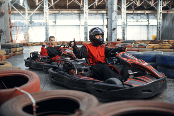 Due piloti di kart, karting auto sport indoor. Gara di velocità su pista di go-kart chiusa con barriera pneumatica. Gara di veicoli veloci, hobby attivo
 - Foto, immagini
