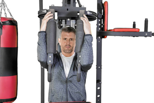 Caucasian man exercises with a fitness machine - Фото, изображение