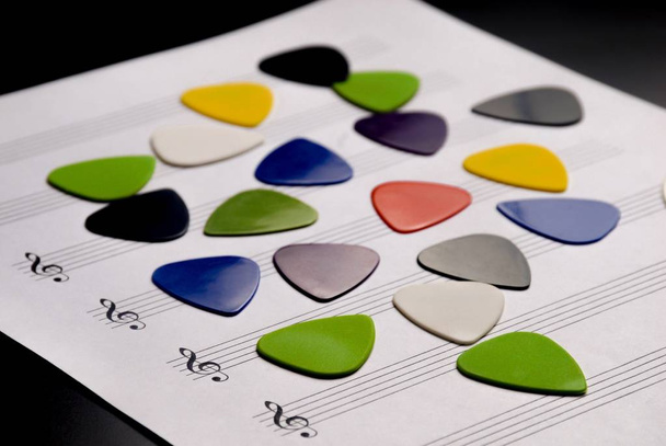 La guitare colorée choisit sur un papier de partition de musique vierge
 - Photo, image