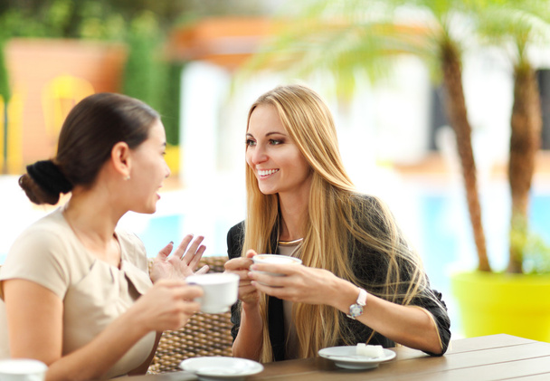 Young women drinking coffee in a cafe outdoors - Foto, imagen