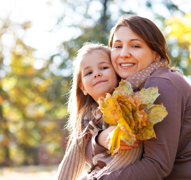 Szczęśliwa młoda matka z córką w parku jesień - Zdjęcie, obraz
