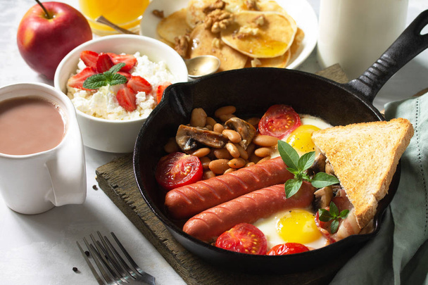 Keto ontbijt: gebakken eieren, worstjes, bonen, spek, champignons, g - Foto, afbeelding