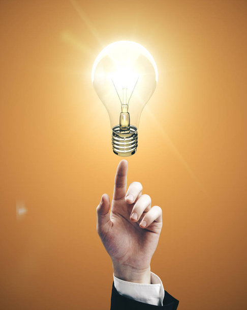 Businessman hand pointing to light bulb - Foto, afbeelding