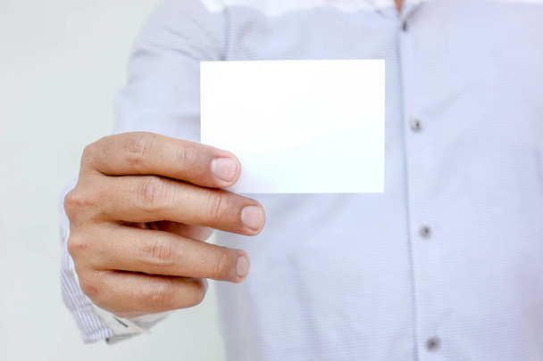Ludzka ręka pokazuje wizytówki - zbliżenie obrazu z białą ba - Zdjęcie, obraz