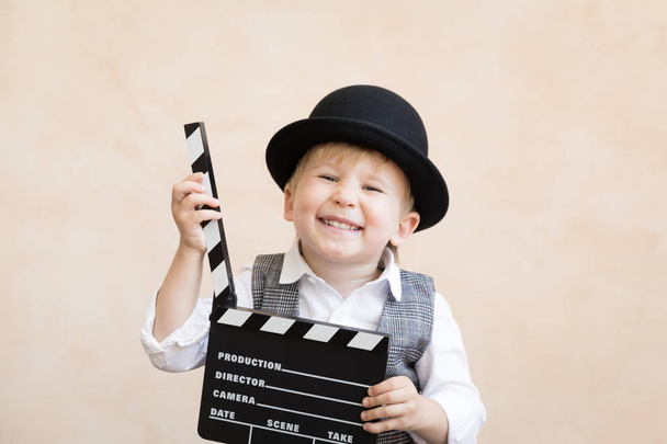 Funny kid holding clapper board - Valokuva, kuva