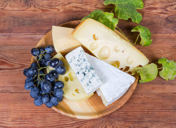 Eri juusto, sininen viinirypäleet puinen ruokalaji maalaismainen pöytä
 - Valokuva, kuva