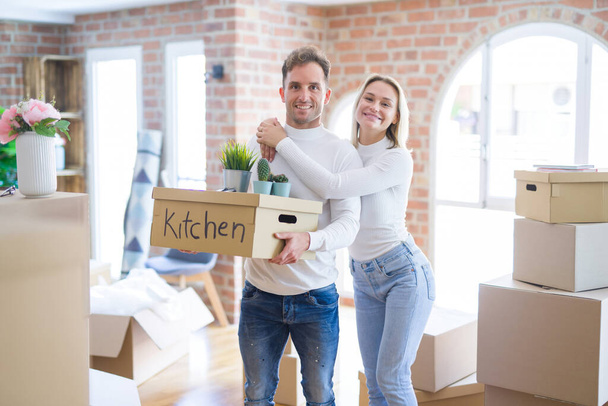 Young beautiful couple moving cardboard boxes at new home - 写真・画像