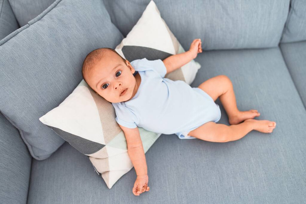 Bambino adorabile sdraiato sul divano a casa. Neonato rilassante e riposante confortevole
 - Foto, immagini