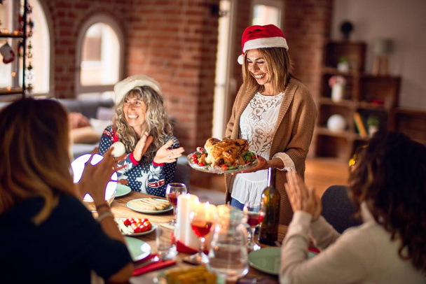 Gyönyörű női csoport mosolyogva boldog és magabiztos. Pörkölt pulyka ünnepli karácsonyt otthon - Fotó, kép