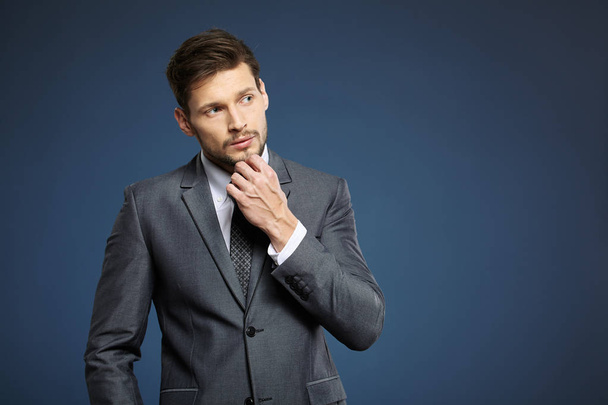 Handsome young business man standing on blue background - Zdjęcie, obraz
