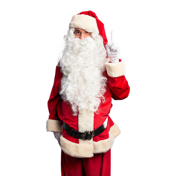 Homem bonito de meia idade vestindo traje de Papai Noel e barba de pé apontando dedo para cima com ideia de sucesso. Saído e feliz. Número um.
. - Foto, Imagem