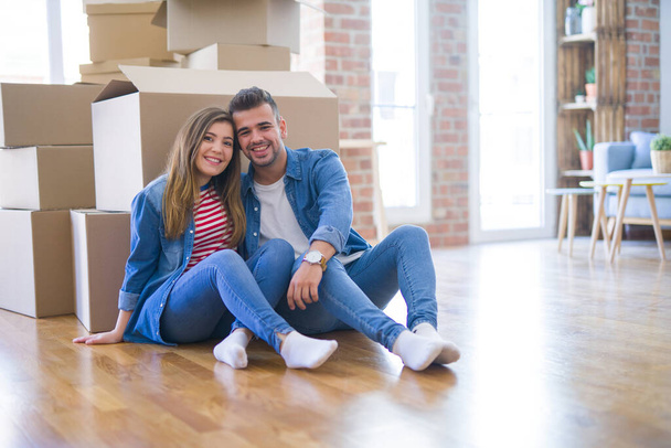 Young beautiful couple in love moving to new home, sitting on th - Photo, Image