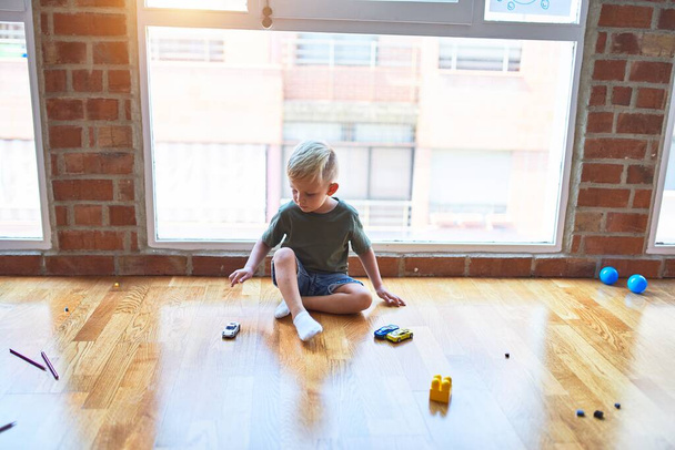 Anaokulunda oyuncaklarla oynayan beyaz bir çocuk. Anaokulu - Fotoğraf, Görsel