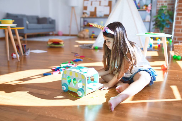 Adorable toddler playing around lots of toys at kindergarten - 写真・画像