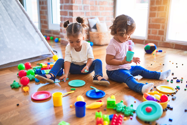 Чарівні малюки грають в їжу з використанням пластикової їжі та столових іграшок в дитячому саду
 - Фото, зображення