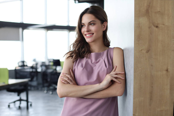 Attractive business woman smiling while standing in the office. - Foto, Imagem