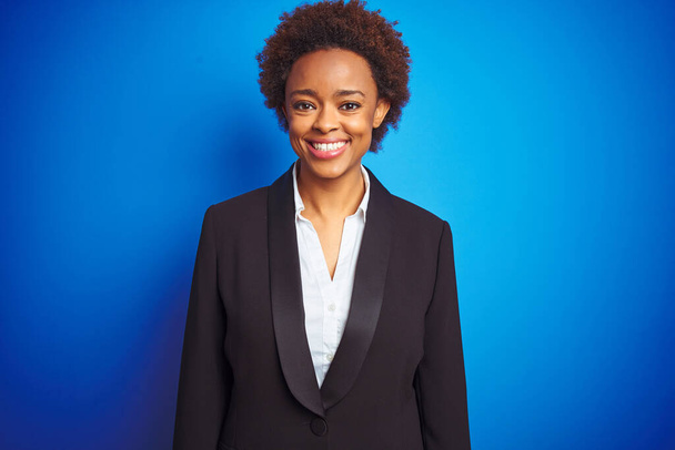 Mujer ejecutiva de negocios afroamericana sobre fondo azul aislado con una sonrisa feliz y fresca en la cara. Persona afortunada
. - Foto, Imagen