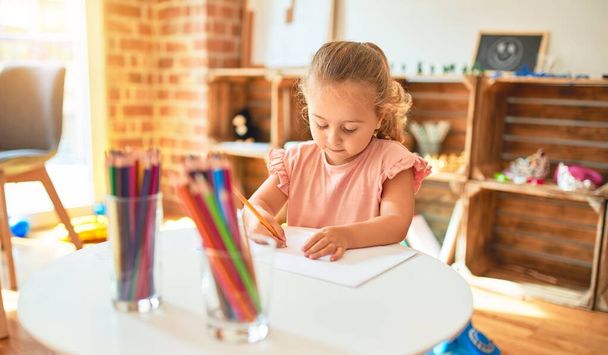 Beau dessin blond de jeune fille avec des crayons de couleur à la maternelle
 - Photo, image