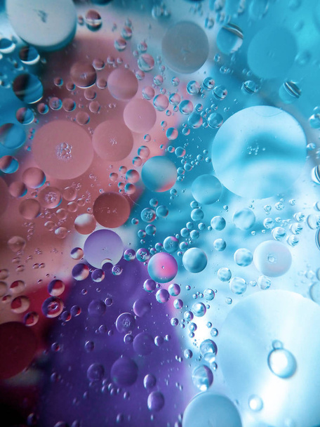 Olej a voda ve skleněné misce na barevném povrchu - Fotografie, Obrázek
