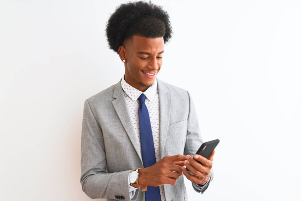Mladý africký americký podnikatel pomocí smartphone přes izolované bílé pozadí s veselou tváří stojí a usmívá se s sebevědomým úsměvem ukazující zuby - Fotografie, Obrázek