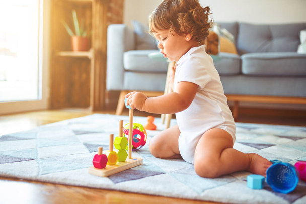 Piękna maluch dziecko dziewczyna bawiąc się zabawkami na dywanie - Zdjęcie, obraz