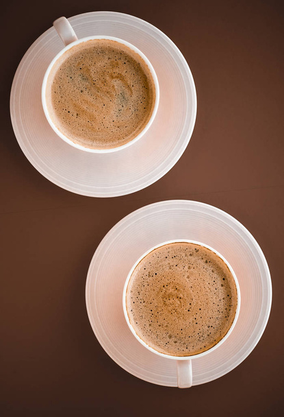 Kopje hete koffie als ontbijt drankje, flatlay cups op bruin terug - Foto, afbeelding