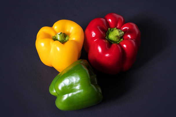 frisches Gemüse drei Paprika auf dunklem Hintergrund. - Foto, Bild