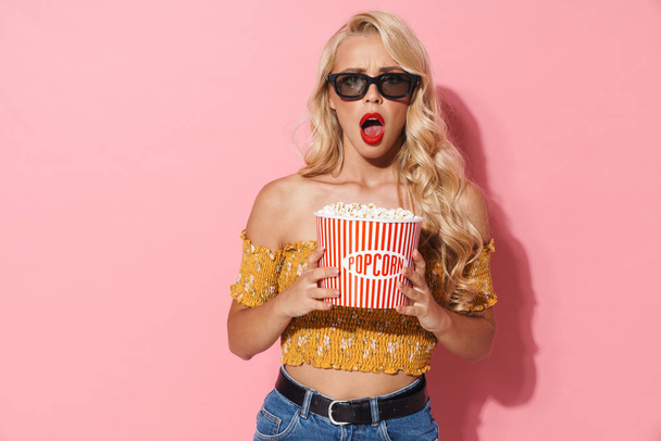 Image of displeased woman in 3d glasses holding popcorn bucket - Photo, image