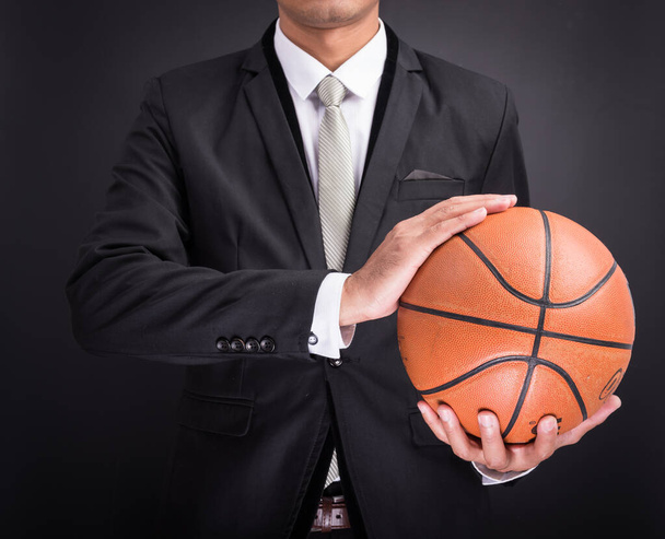 Young businessman holding basketball ball - Foto, imagen