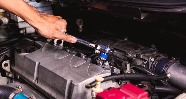 Hand of auto mechanic technician service engine and using wrench - Фото, зображення