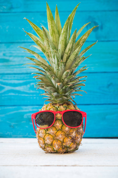 Holiday pineapple have sunglasses on blue wooden background - Zdjęcie, obraz