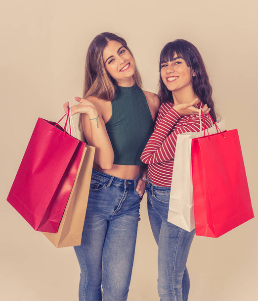 Excited teenagers with shopping paper bags buying on black friday or season sales. Friends women shoppers holding colorful bags happy and cheerful after shopping day. Fashion and and shop addiction. - Photo, image