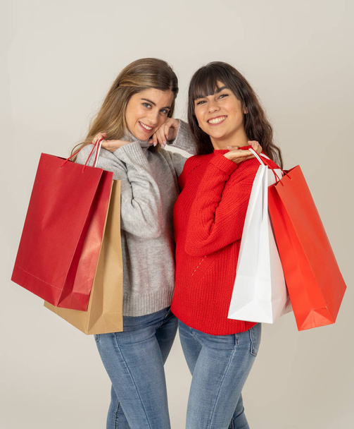 Excited teenagers with shopping paper bags buying on black friday or season sales. Friends women shoppers holding colorful bags happy and cheerful after shopping day. Fashion and and shop addiction. - Foto, imagen