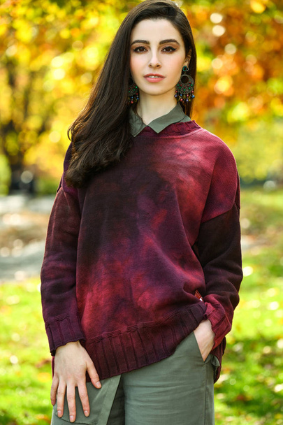 Young brunette woman walking in autumn park. Outdoor fashion style. - Fotoğraf, Görsel