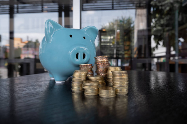 blaues Sparschwein mit Münzhaufen, Wachstumsförderung zum Erfolg und Sparen für das Rentenkonzept - Foto, Bild