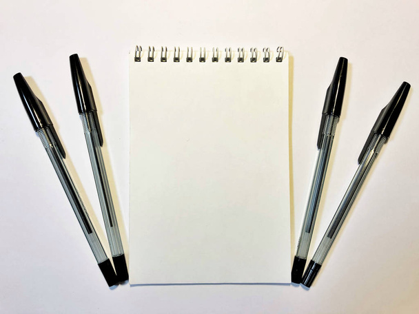 otwarty notatnik z czarnym piórem na białym biurku, przestrzeń do kopiowania - Zdjęcie, obraz