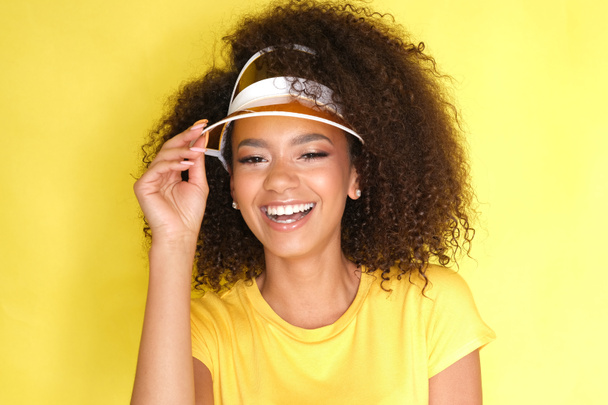 ¡Qué hermosa sonrisa! Afro chica en ropa amarilla sobre fondo amarillo
. - Foto, Imagen