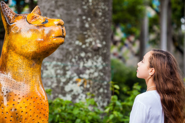 Молодая девушка туристка посещает знаменитые статуи кошки, сделанные различными художниками в городе Кали в Колумбии
 - Фото, изображение