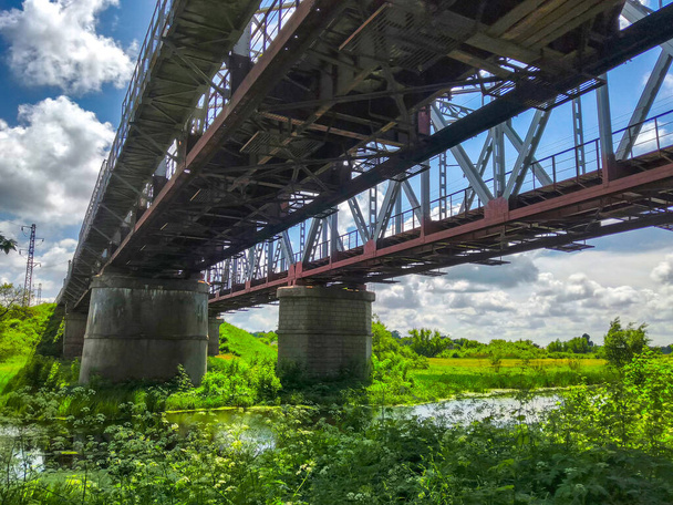 Bouw van een weg- of spoorwegbrug met steunpilaren boven de rivier - Foto, afbeelding