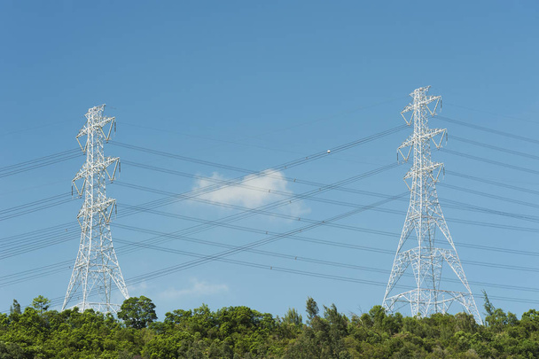 Pilón eléctrico y línea eléctrica con fondo de cielo azul
 - Foto, imagen