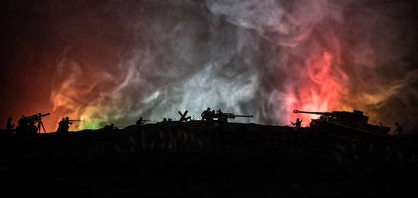 Concepto de guerra. Siluetas militares que luchan escena en el fondo del cielo niebla de guerra, Guerra Mundial tanques alemanes siluetas debajo del horizonte nublado Por la noche. Escena de ataque. Vehículos blindados e infantería
. - Foto, imagen