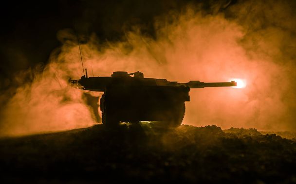 戦争の概念。夜間の戦争霧の空の背景に装甲車両のシルエット戦闘シーン。戦う準備ができているアメリカの戦車. - 写真・画像