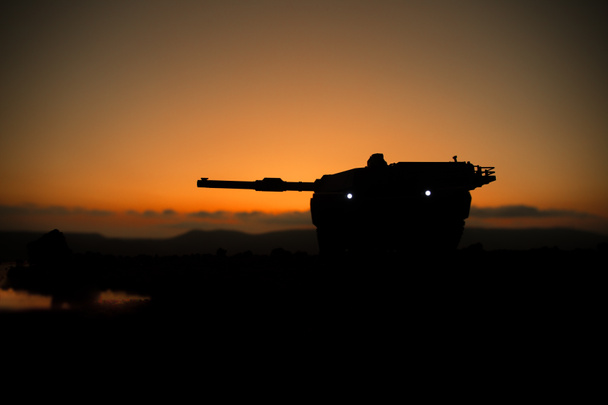 Válečný koncept. Obrněná silueta vozidla bojující na pozadí válečné mlhy. Americká nádrž při západu slunce. - Fotografie, Obrázek